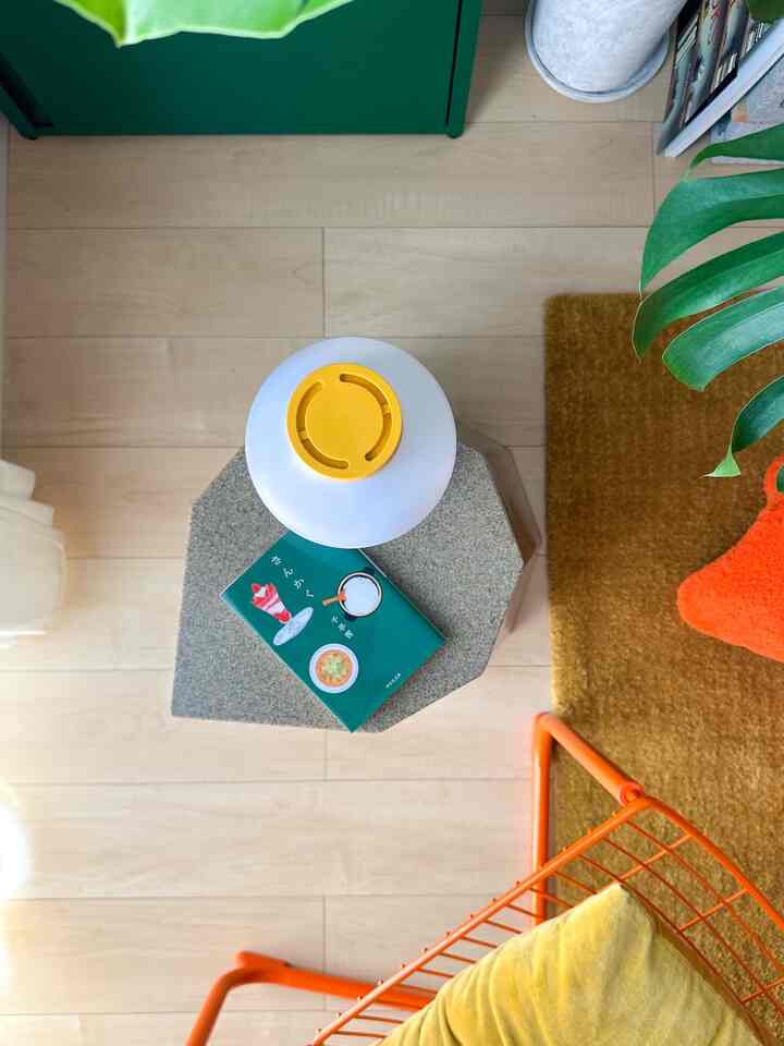 A natural-toned small space with yellow and brown hues, featuring the Arnold Circus Stool used as a side table