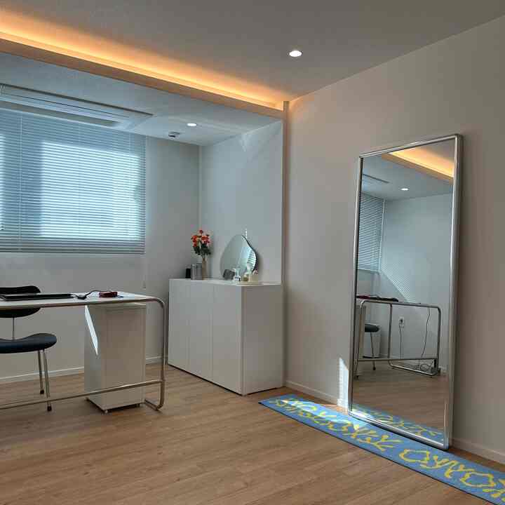 白と木目調の書斎、ミッドセンチュリーモダン家具と大きな全身鏡が配置された印象的な空間