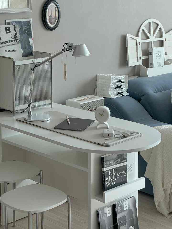 白と青のトーンのリビングルーム、アーチ型アイランドテーブルとソファ、スツールが配置されたミニマルでモダンな空間