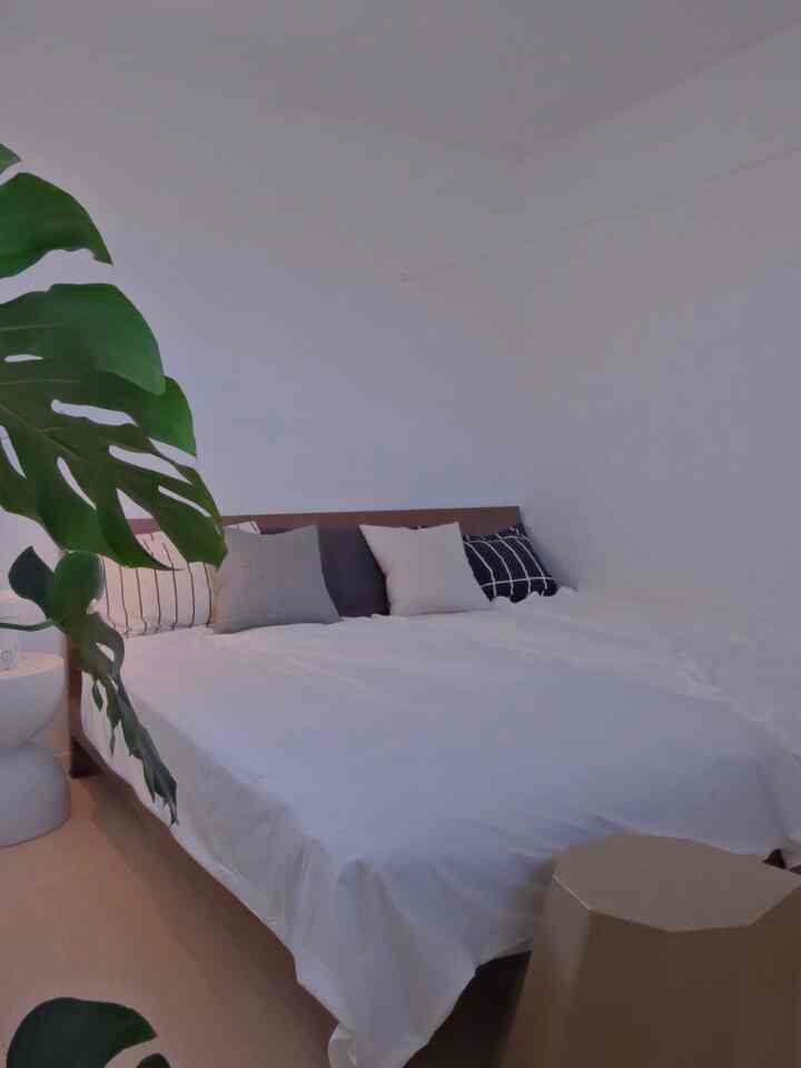 A Nordic style bedroom with harmonious white and wood tones, featuring simplicity and a calm atmosphere