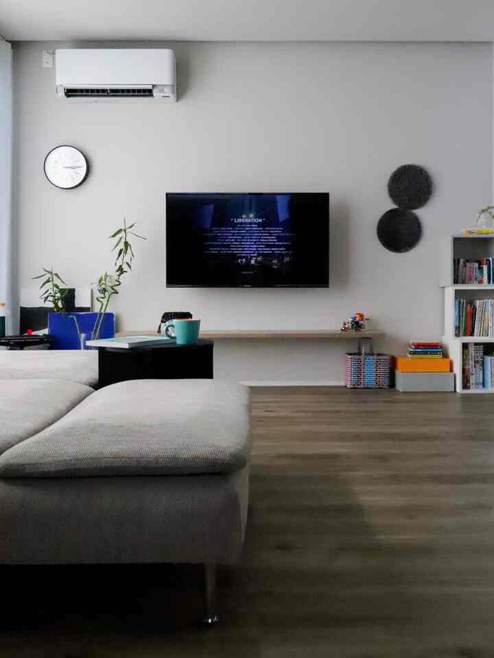 白とナチュラルカラーのリビング、テレビと子供のおもちゃ収納が整然と配置された雰囲気のあるインテリア