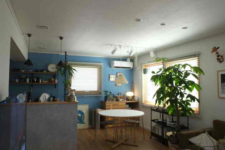 明るい白と青のトーン、木製の床と植物が配置された北欧スタイルのリビングとダイニングの空間