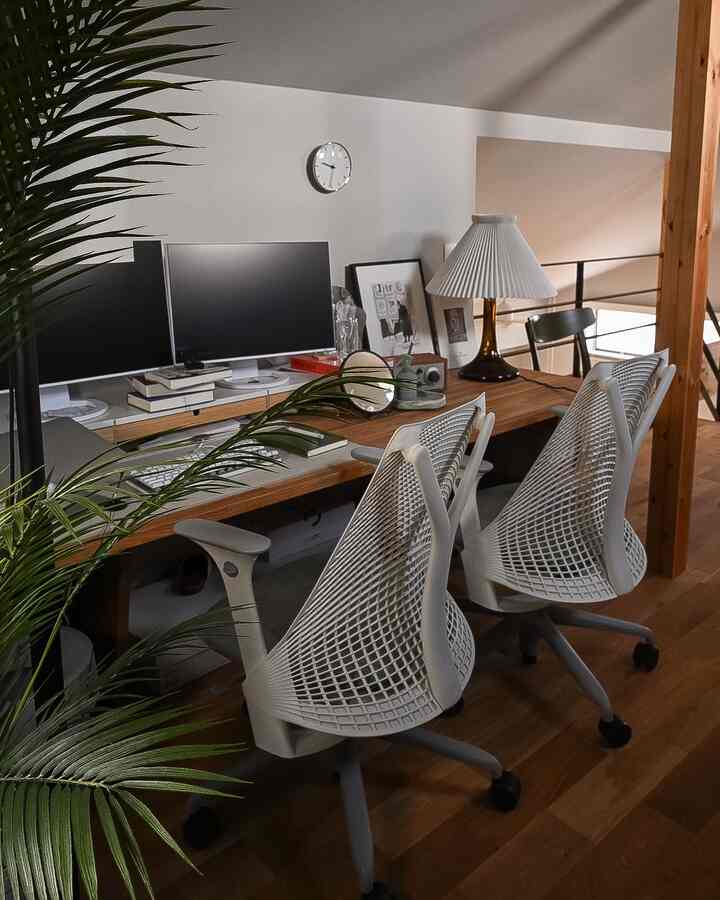 白いチェアと木目調のデスクが配置された明るく居心地の良いワークスペース