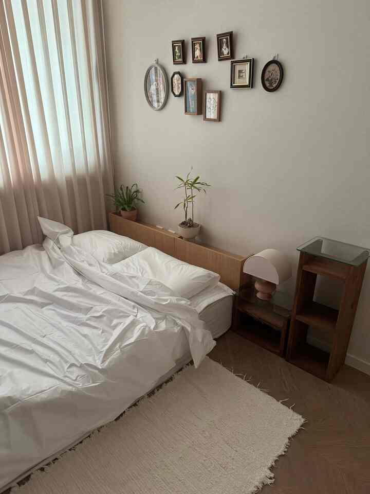 White and wood tone bedroom featuring hotel-like bed and curtains with cozy atmosphere