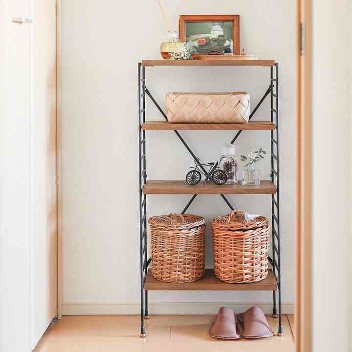 ナチュラルカラーのコンパクトな玄関、木製棚とラタンバスケットが配置された収納アイデアのある雰囲気のインテリア