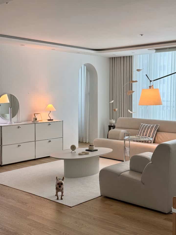 白と木目調が調和したリビング、シンプルなソファとコーヒーテーブルが配置された落ち着いた空間