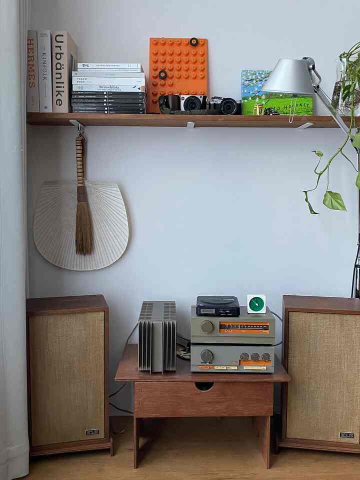 Wood tone and white wall retro style corner featuring vintage audio equipment and wood floating shelf in living room
