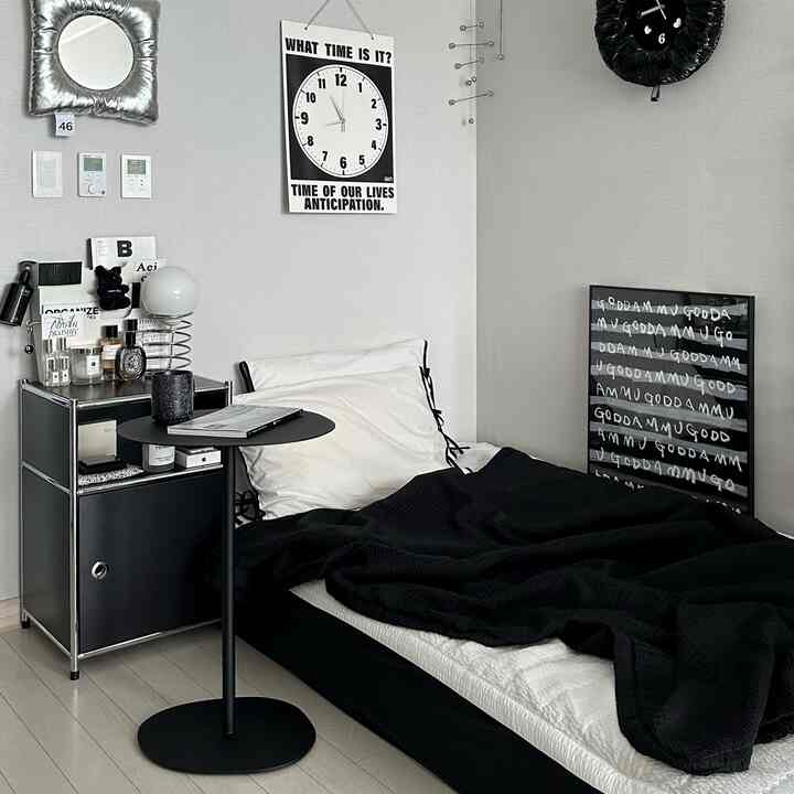 Black and white toned bedroom featuring a simple modern bed and nightstand arranged in a cozy space