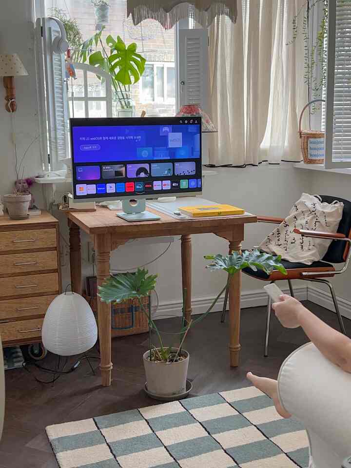 ナチュラルカラーのホームオフィス、木製の机とモニター、観葉植物が配置された雰囲気のあるインテリア