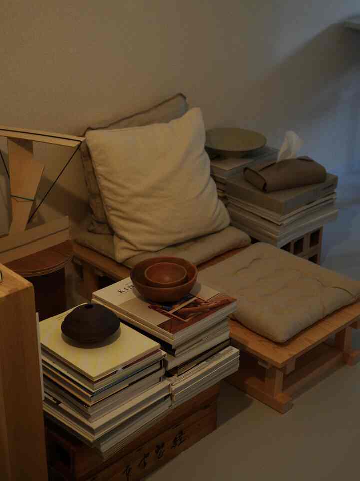 Soft beige tone reading nook featuring wooden pallets and cushions creating a cozy study atmosphere