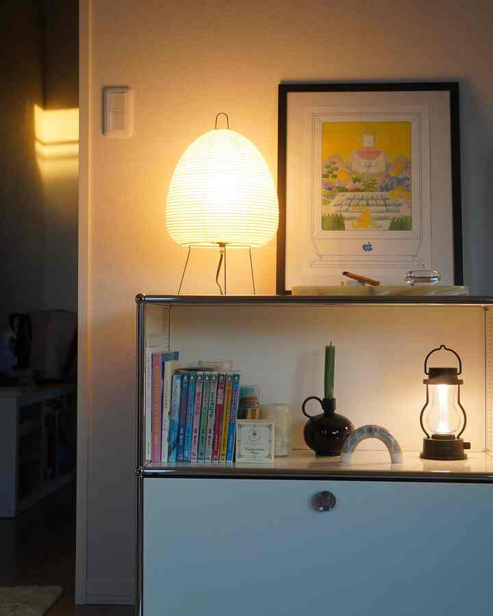 暖かいホワイトライトのサイドボード空間、照明と額装アートが落ち着いた雰囲気を作るリビングインテリア