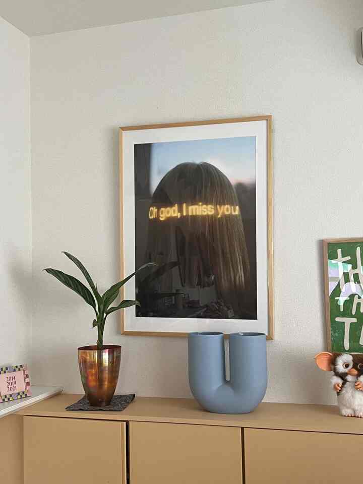 ナチュラルカラーのダイニング横収納スペース、額縁のアートと植物、オブジェが配置された雰囲気のあるインテリア