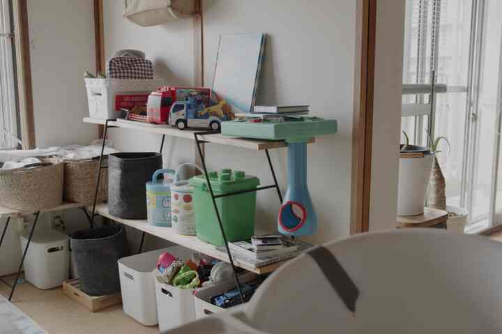 White and natural wood tone kids' space featuring DIY shelves and toy storage bins with a cozy atmosphere