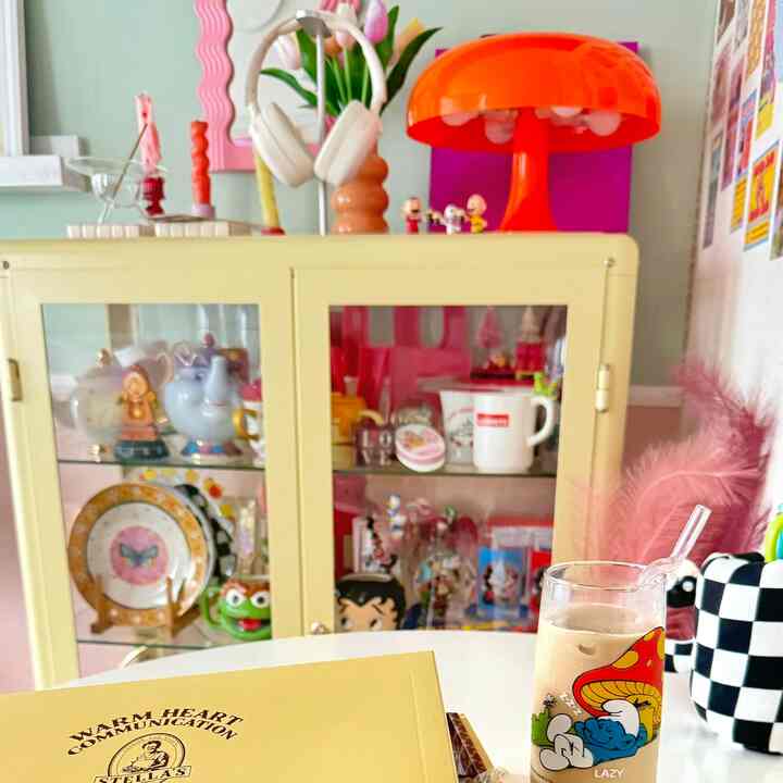 明るい黄色のキャビネットとピンクのアクセントが調和した、一人暮らし向けのカフェ風リビング