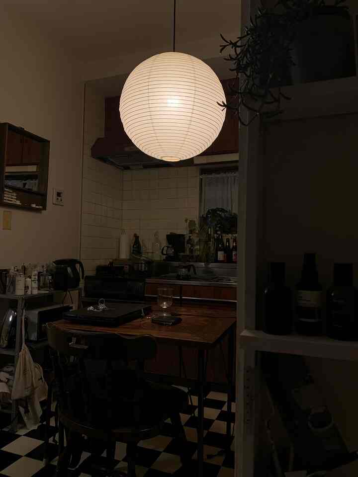 白いタイルと木目調家具が配置されたワンルームキッチン、ホームカフェ用品が置かれた雰囲気のある空間