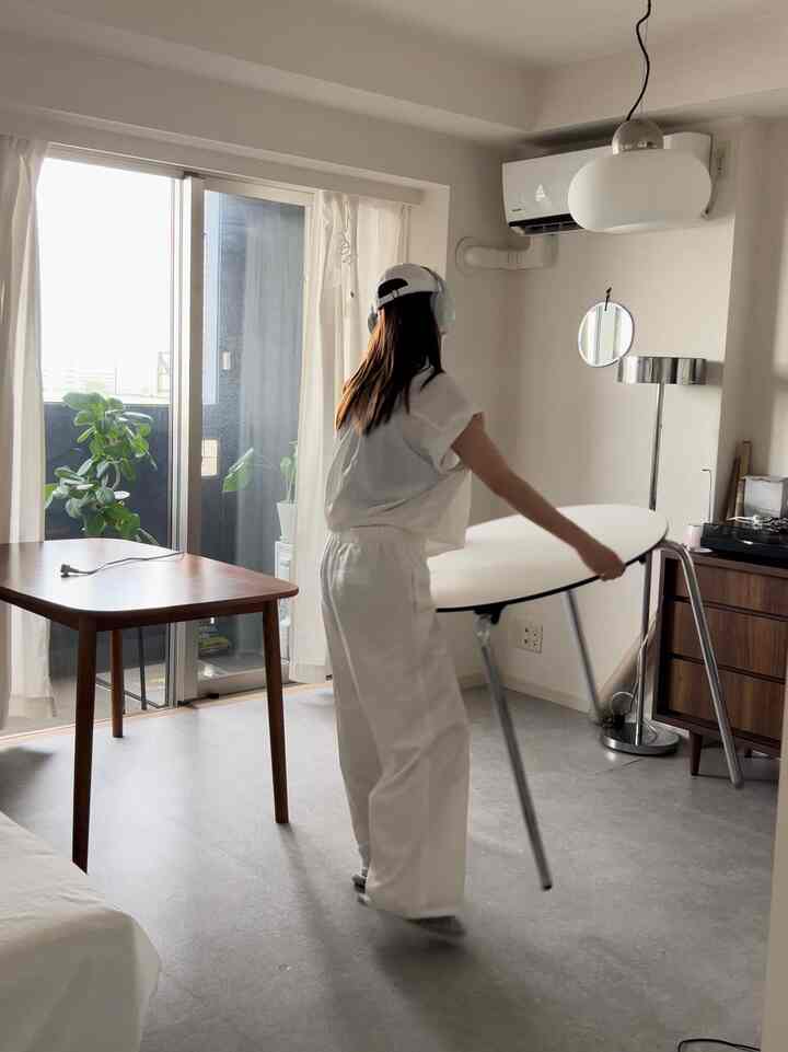 白と茶色の落ち着いた色調のリビング、2つのテーブルとフロアランプが配置された雰囲気のあるインテリア