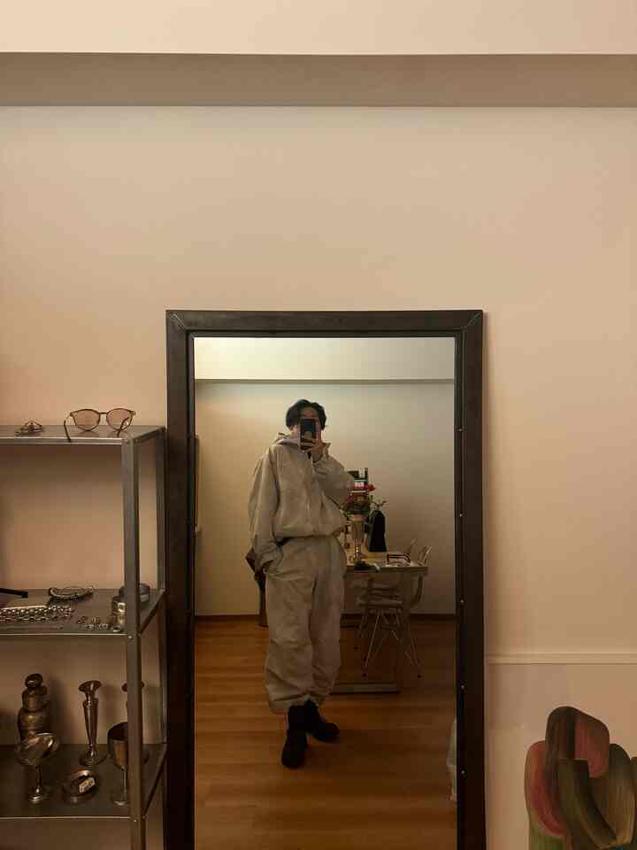 Natural tone living room featuring a large mirror and metal shelf creating a cozy atmosphere