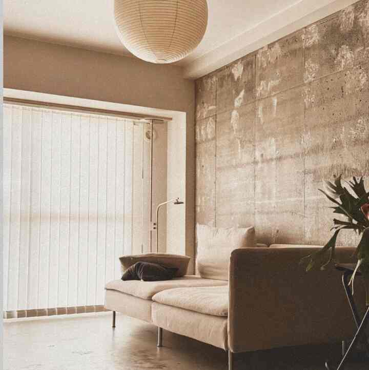 ベージュとナチュラルカラーのワンルームリビング、ソファとペンダントライトが配置された雰囲気のあるインテリア