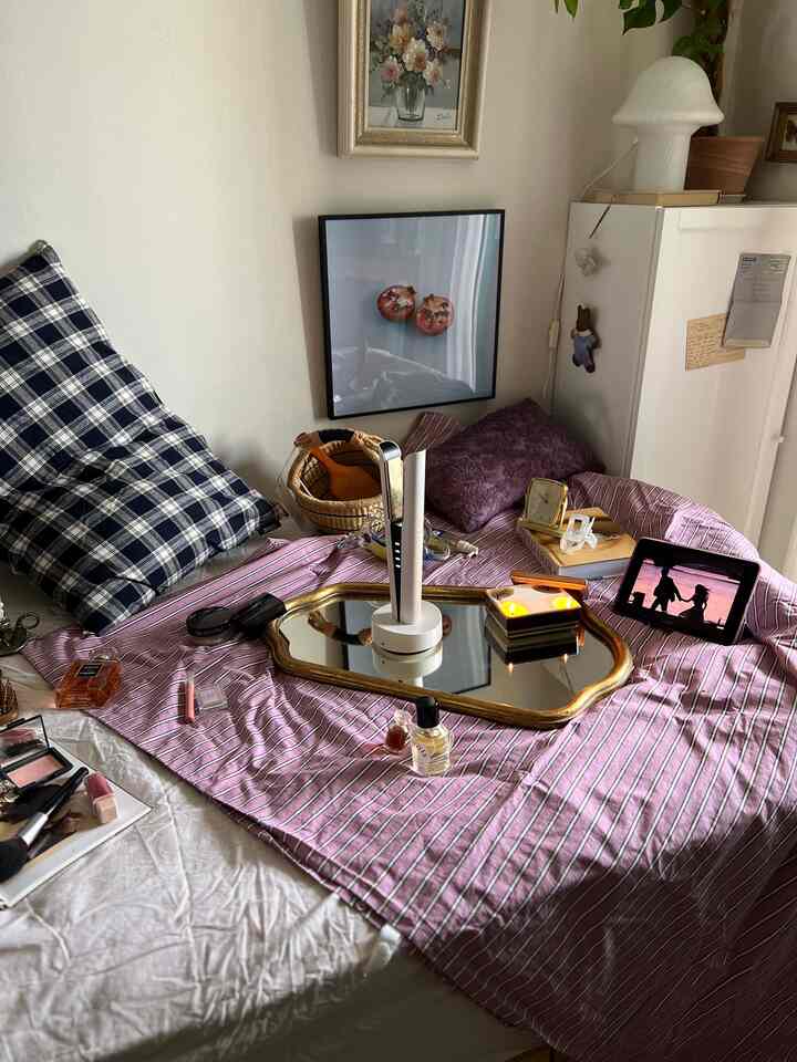 白を基調としたヴィンテージ風寝室、ベッド上にヘアアイロンと鏡、枕が配置された雰囲気のあるインテリア