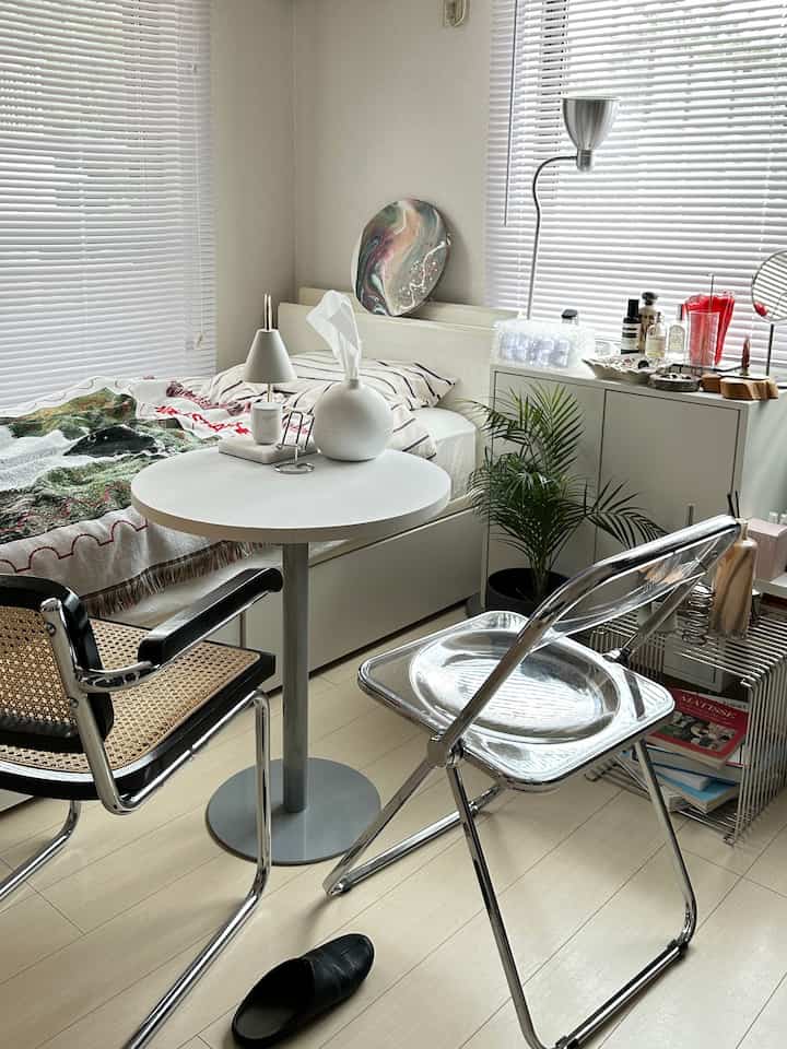 明るい白とベージュの色調の寝室、シンプルな家具とさまざまな小物が配置された落ち着いた雰囲気のインテリア