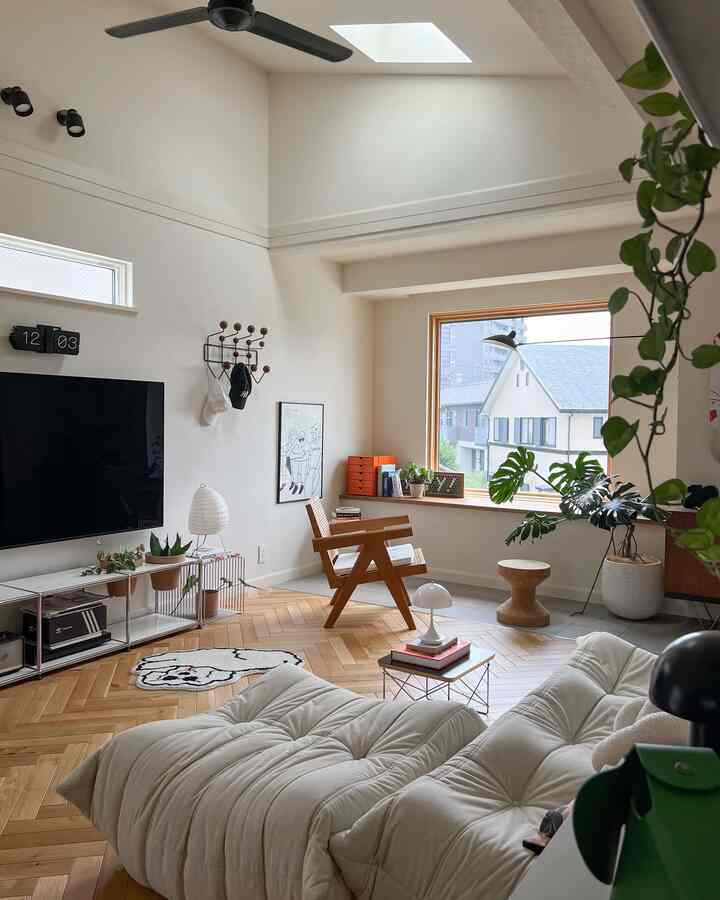 Natural modern living room with dominant white and wood tones, featuring ample daylight, plants, and minimalist furniture for a cozy atmosphere