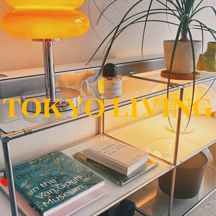 白い壁と黄色の照明が印象的な韓国インテリアのリビングの棚にオブジェが配置された温かみのある空間