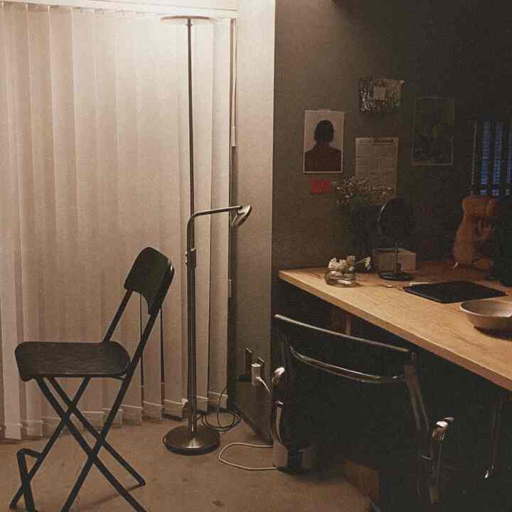 黒い椅子とナチュラルウッドの机が配置された暖かい雰囲気のホームオフィス