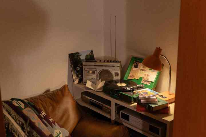 温かみのあるブラウンとオレンジの色調の書斎、ビーズクッションとレトロなオーディオ機器が配置された雰囲気のあるインテリア