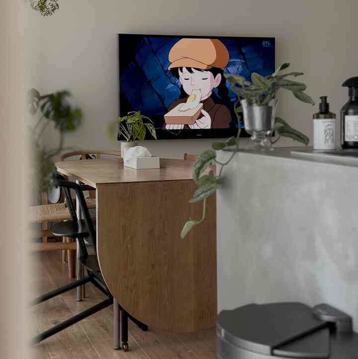 ナチュラルな木目調と緑の植物が配置されたダイニングキッチン、落ち着いた雰囲気のあるインテリア