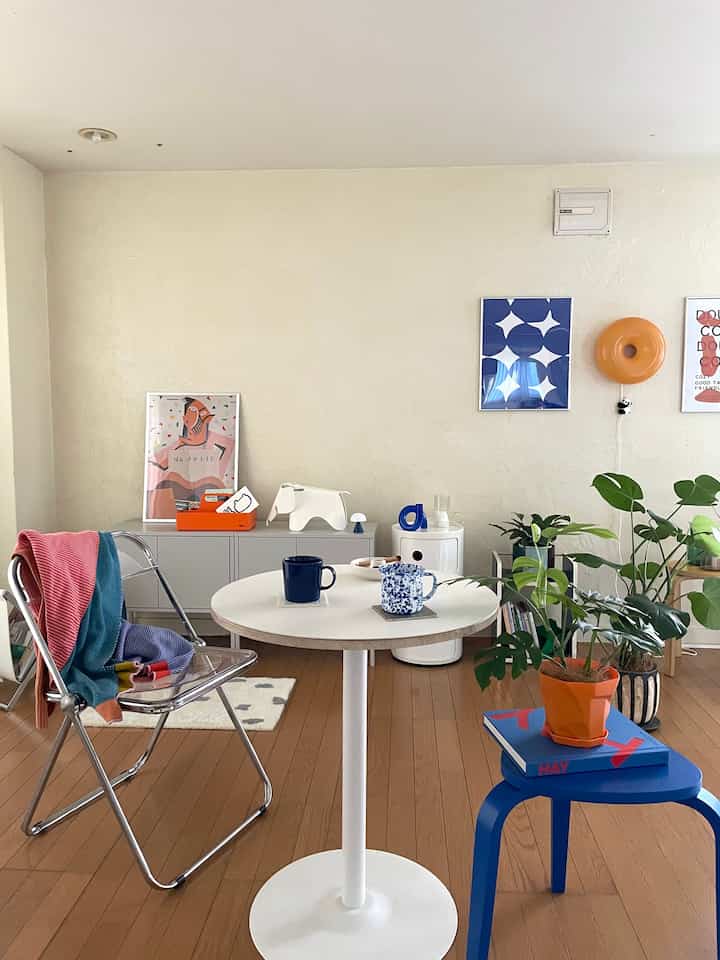 White and brown toned two-person dining room featuring posters, plants, and a cozy home cafe vibe