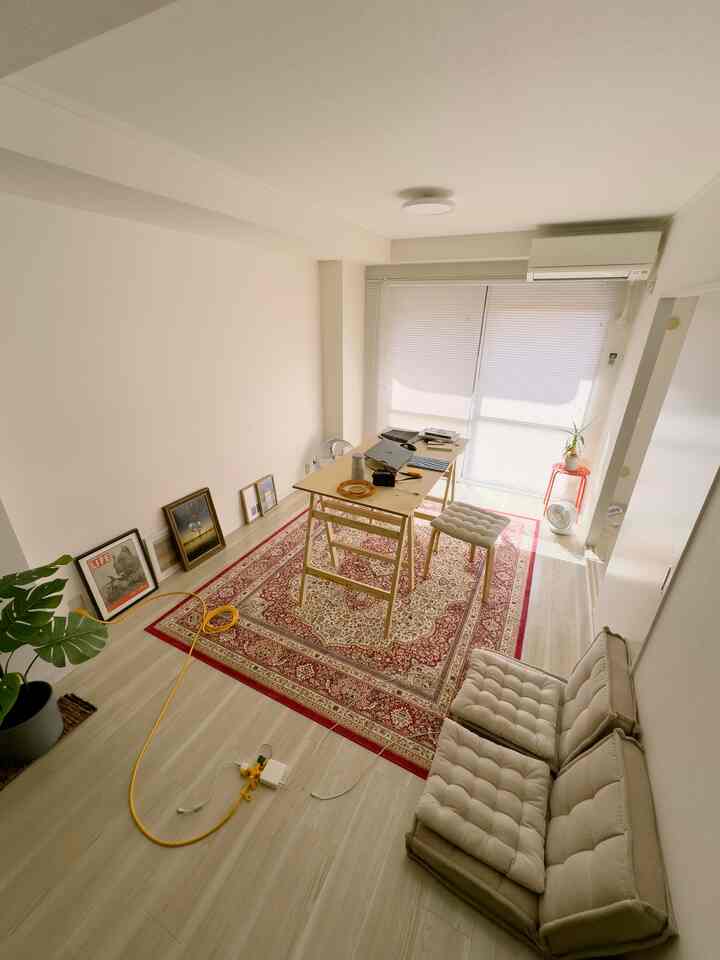 White and wood tone single household living room home office featuring rug and sofa bed with a simple warm atmosphere
