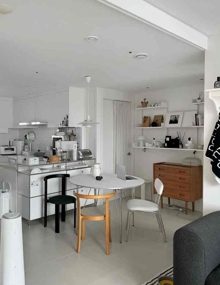 白を基調としたダイニングキッチン、丸テーブルと木目調の椅子が配されたシンプルモダンなインテリア