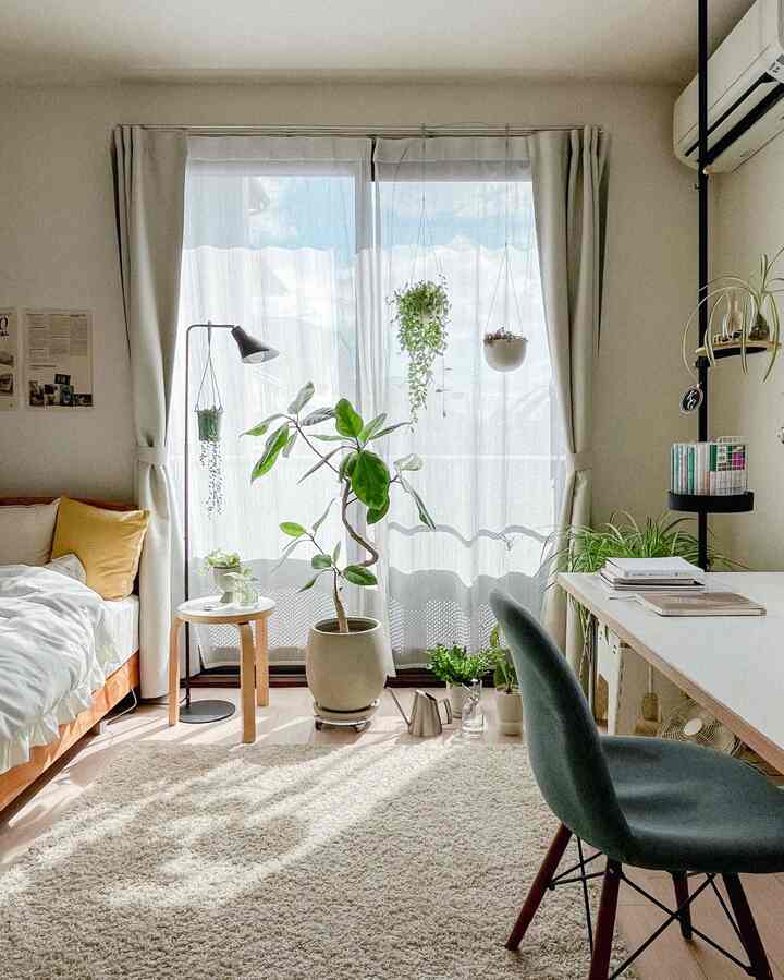Bright white and beige toned 1K studio featuring multiple plants and a desk in a cozy Nordic style interior