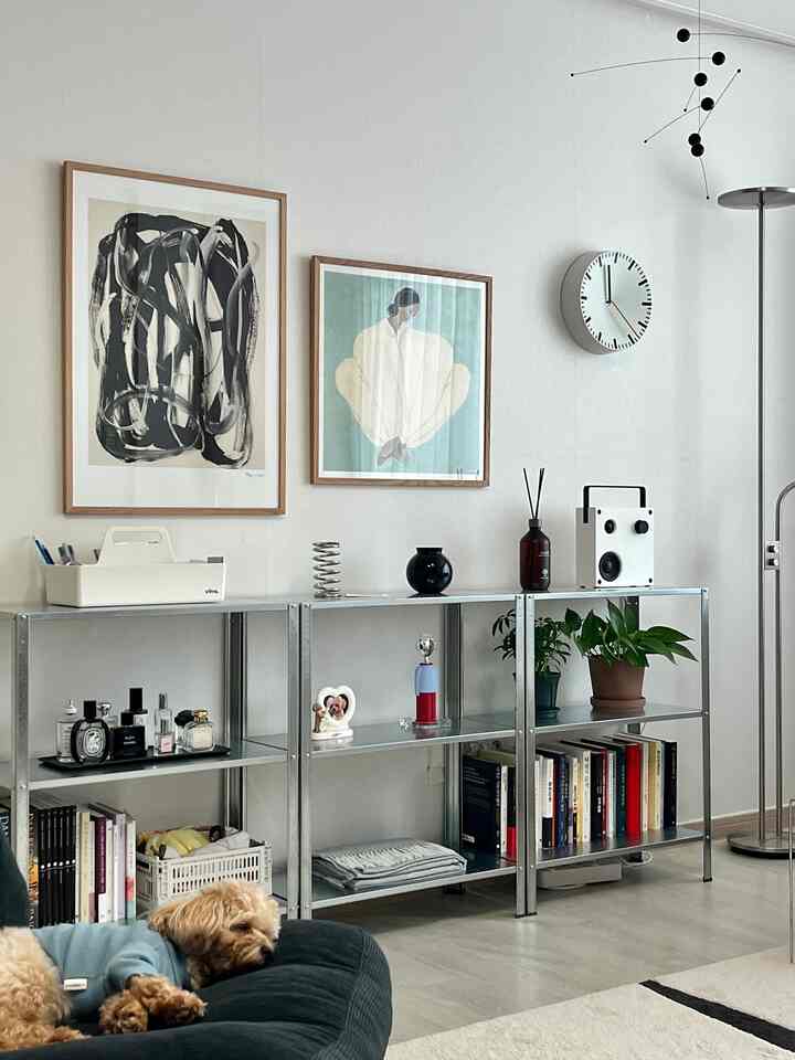 落ち着いた色調のリビング、メタルシェルフと木製額縁のアートが配されたモダンな北欧風インテリア