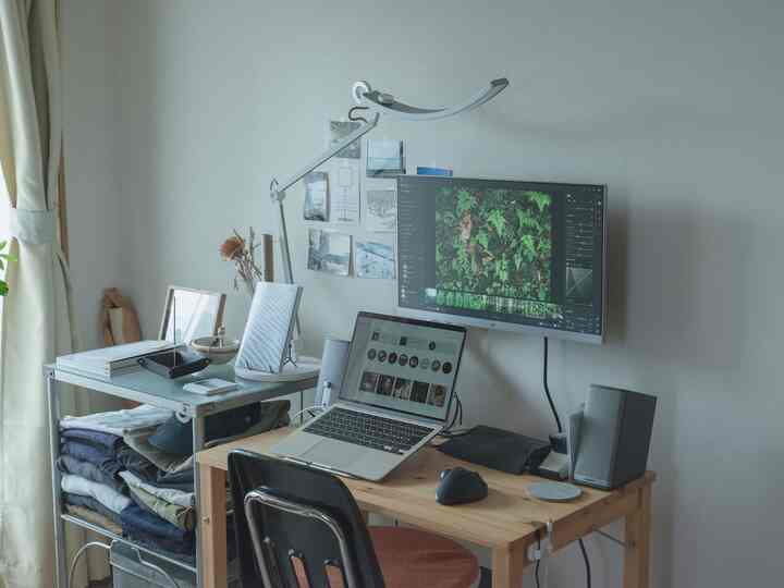 White-walled single household home office with natural wood desk, ideal for remote work in a clean, compact space