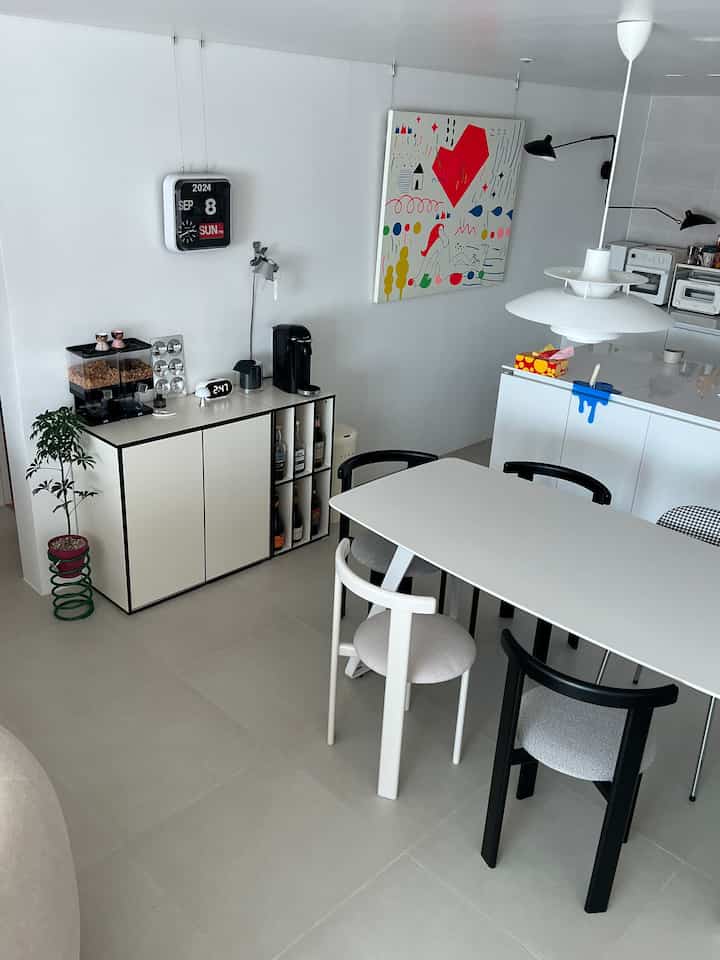 ホワイトとブラックのトーンのモダンなキッチン空間、ワインラックとおうちカフェ要素が配置された清潔感のあるインテリア