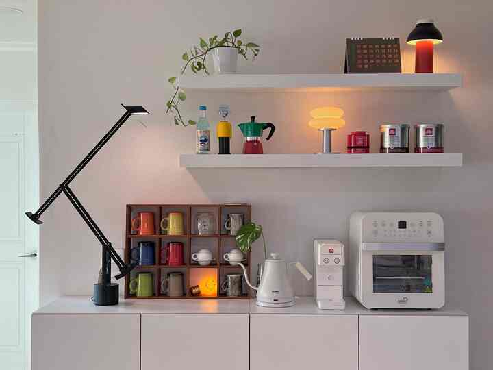 白と黒のトーンが特徴のキッチンおうちカフェ空間、棚や照明、整理されたマグカップとキッチン家電が配置されたモダンなインテリア