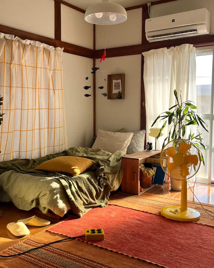 やわらかい黄色とブラウンの色調のナチュラルな寝室、日差しの入る心地よい空間