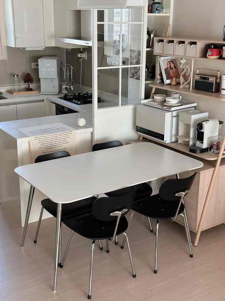 A white and black contrasted kitchen and dining table, featuring a sleek and modern atmosphere