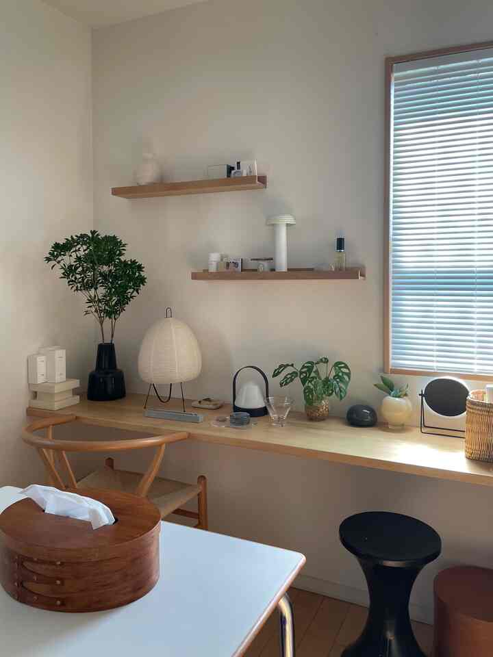 ナチュラルトーンの小さなホームオフィス、木製のデスクと棚、さまざまな植物が配置されたシンプルなインテリア