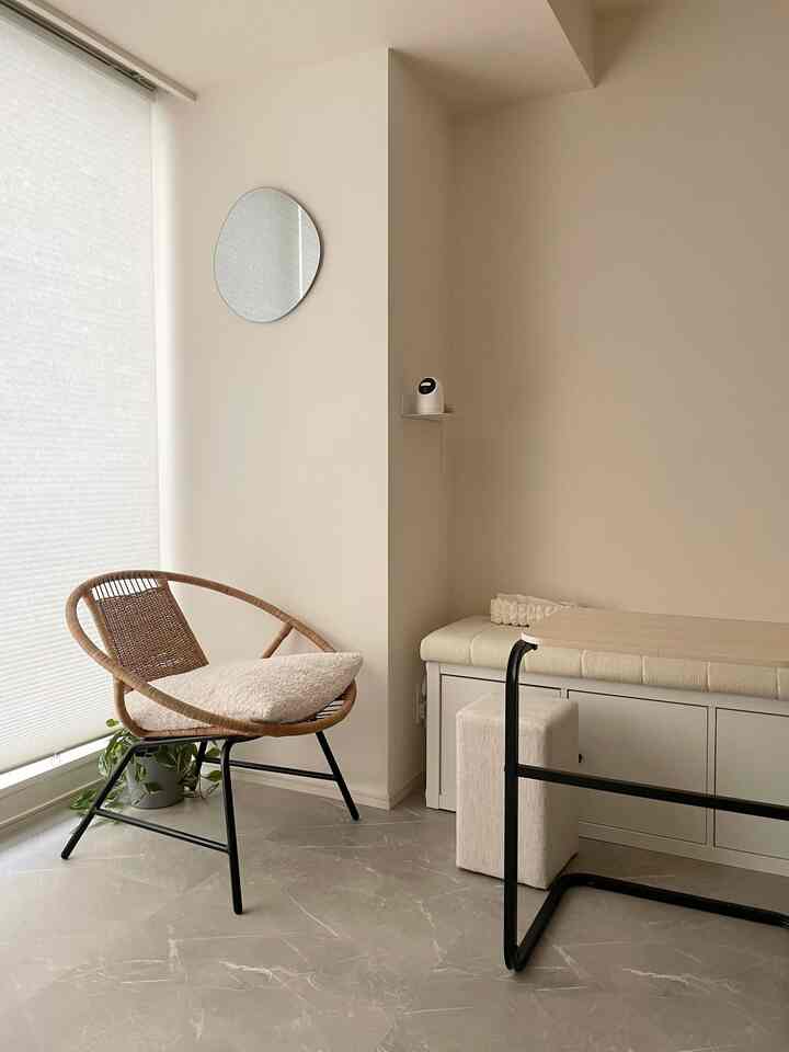Natural-tone 6畳 living room with white walls, gray marble floor, rattan armchair, and bench