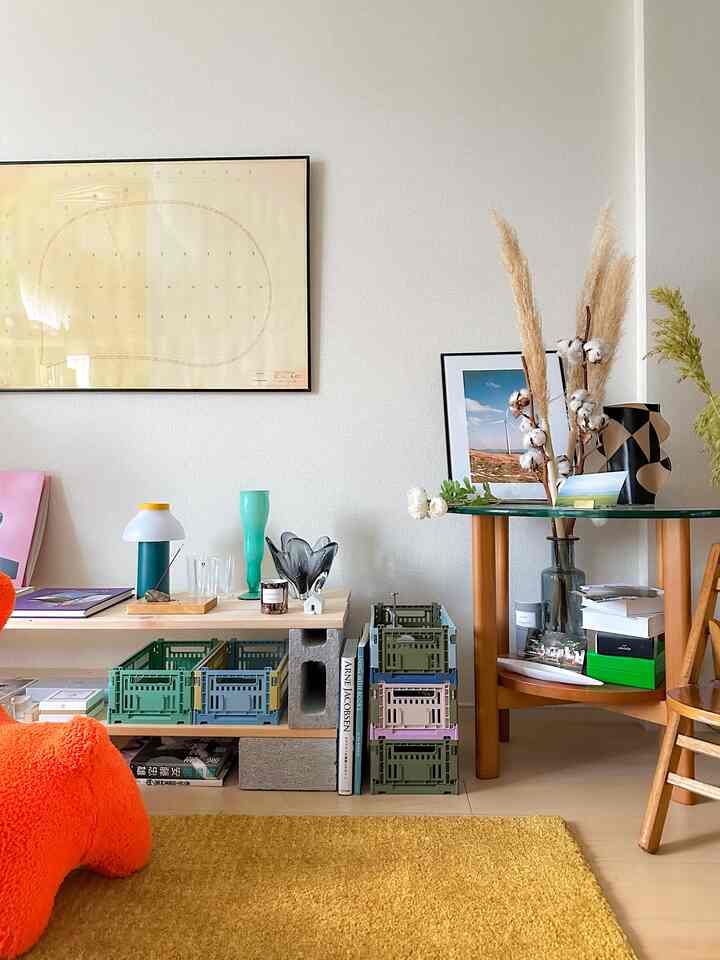 Living room with yellow rug, featuring HAY COLOUR CRATE storage crates and a table lamp in a natural toned setting