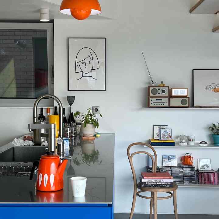 Red and white toned kitchen featuring a vintage teapot and bookshelf with modern interior style