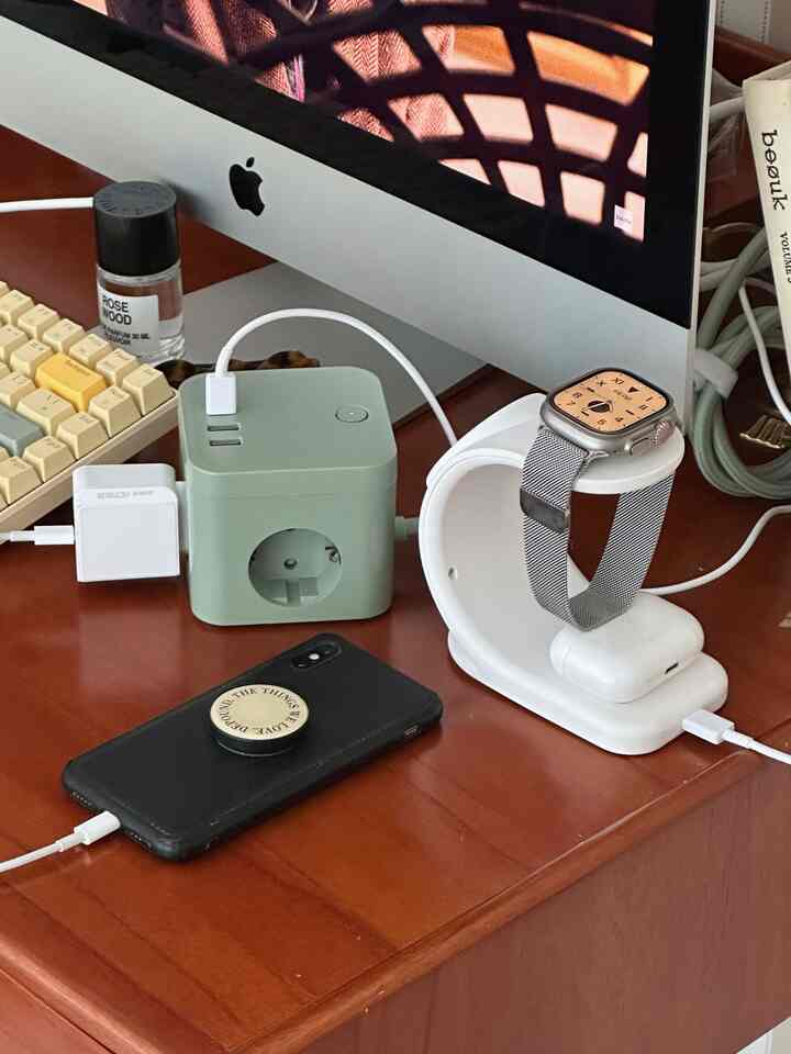 茶色の木目調デスクに白い充電スタンドとコンピューターモニターが配置された整ったホームオフィスのインテリア