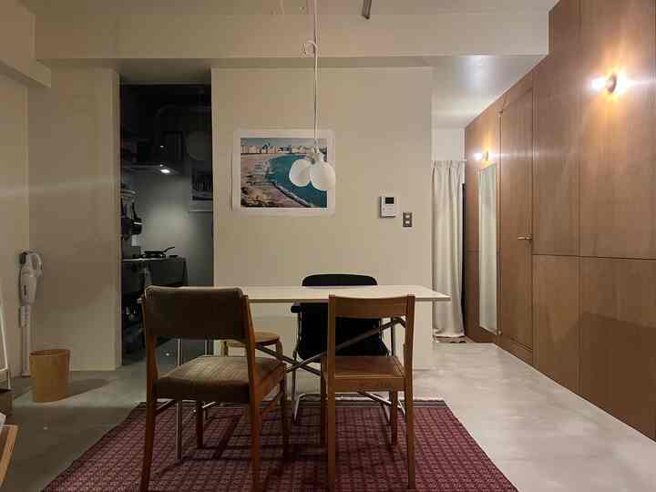 White and brown toned dining room featuring a central dining table and chairs, with a modern and mid-century modern style blend
