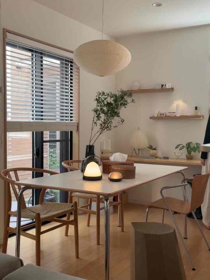White and brown toned dining room featuring natural wood furniture and silver table legs in a clean, simple space