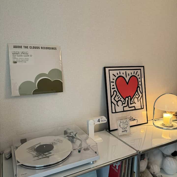 白を基調としたシンプルでモダンな空間、レコードプレーヤーやキャンドル、壁アートが配置された韓国風インテリア