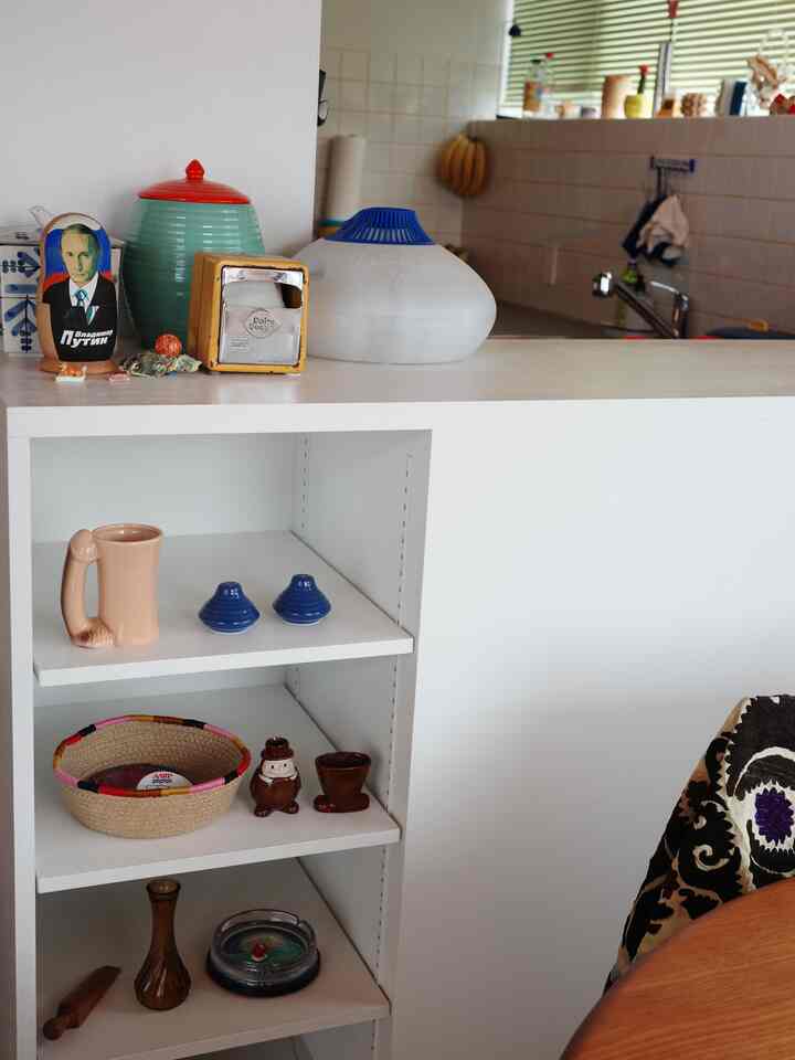 白を基調としたキッチン、棚とキッチン小物が配置された雰囲気のあるインテリア