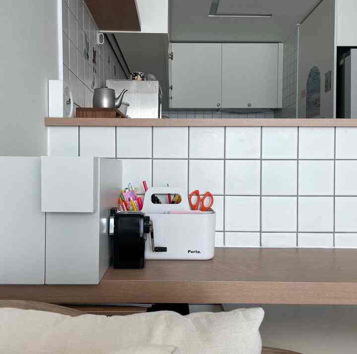 ホワイトとウッドトーンのキッチン、実用的な間仕切り棚が配置された温かみのある空間