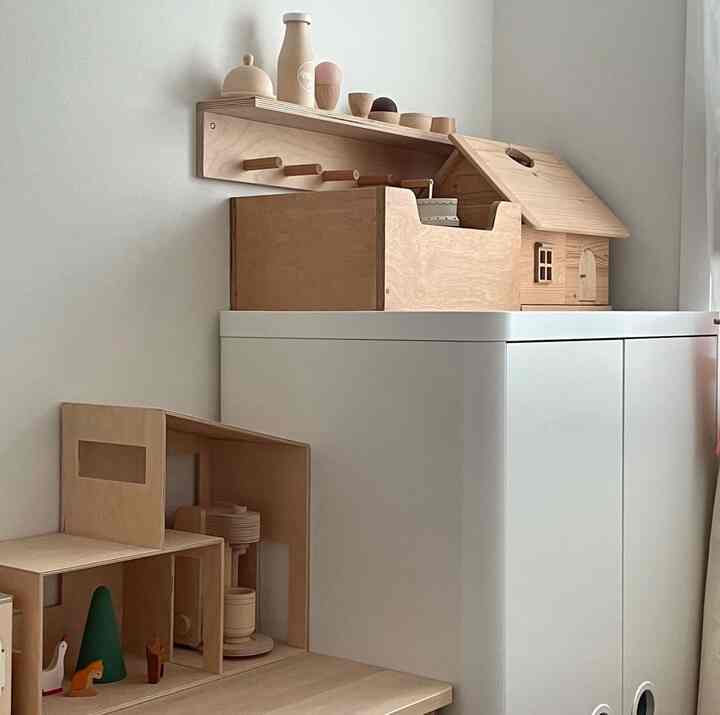 白と木目調が調和した子供部屋、木製のおもちゃとイケアのワードローブが清潔に配置された落ち着いた空間